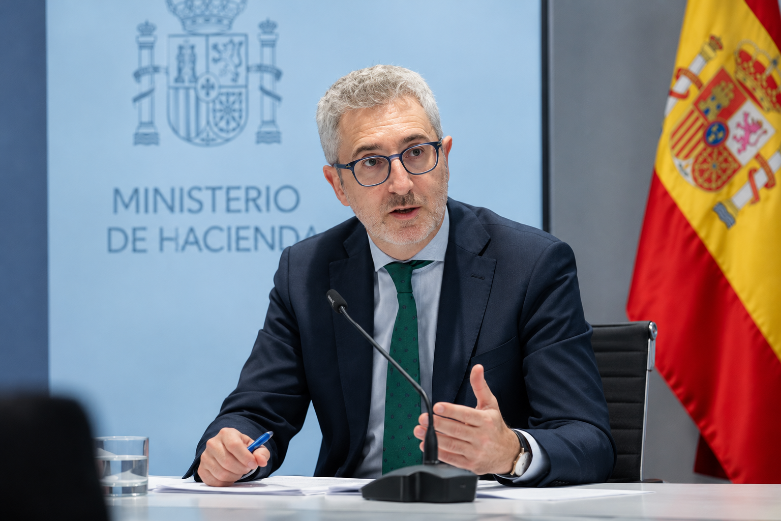 Arcadi España, ministro de Hacienda, hablando ante un micrófono durante una comparecencia en el Ministerio